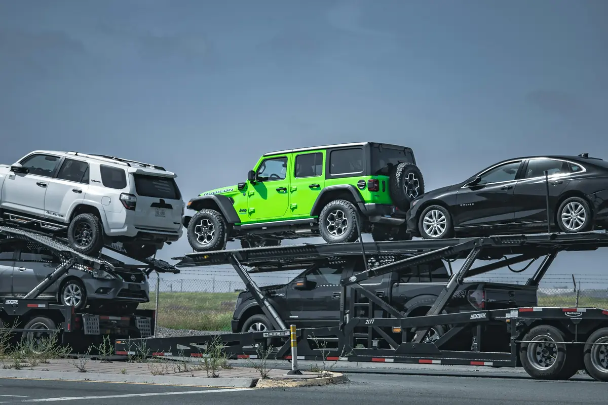 Two-level open car carrier loaded with SUVs and sedans